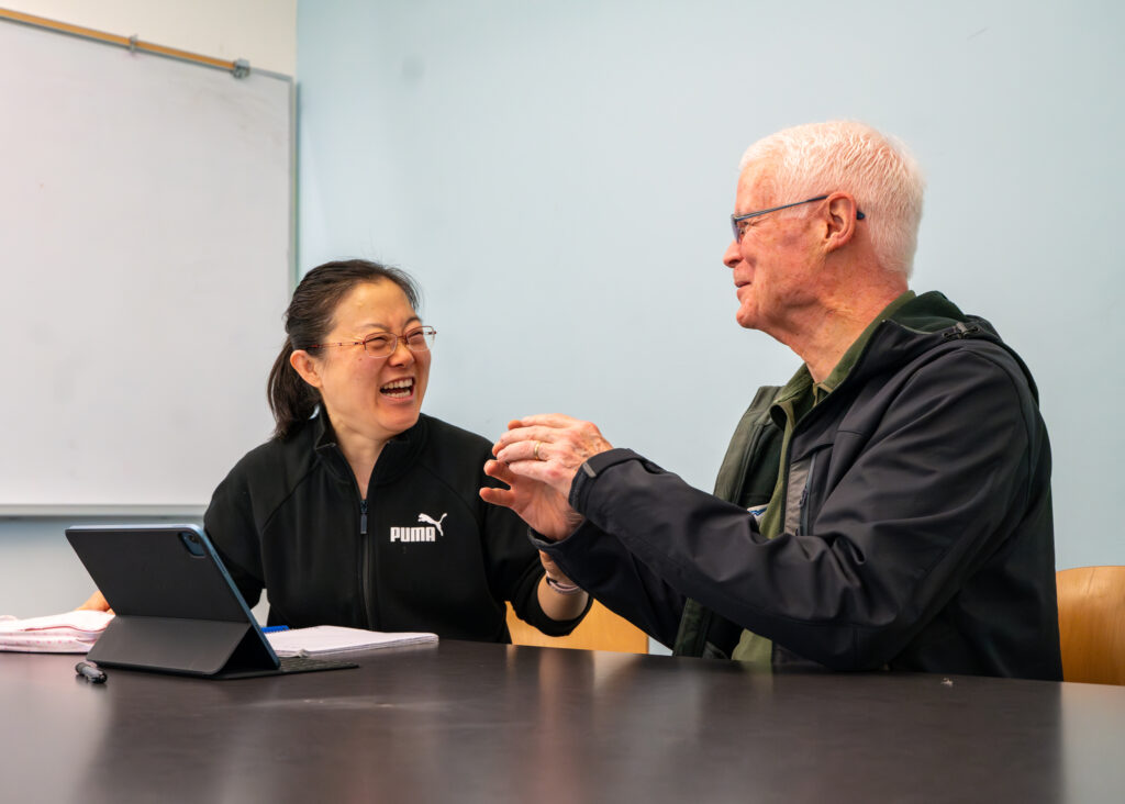 Bob and Junyi share a laugh during an adult education session.
